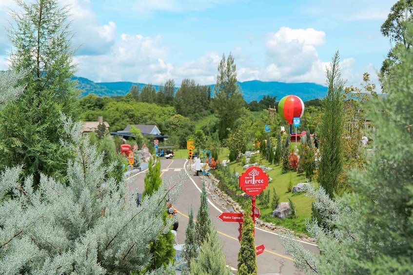 A road with a red sign, trees, and a mountain in the background. 3
