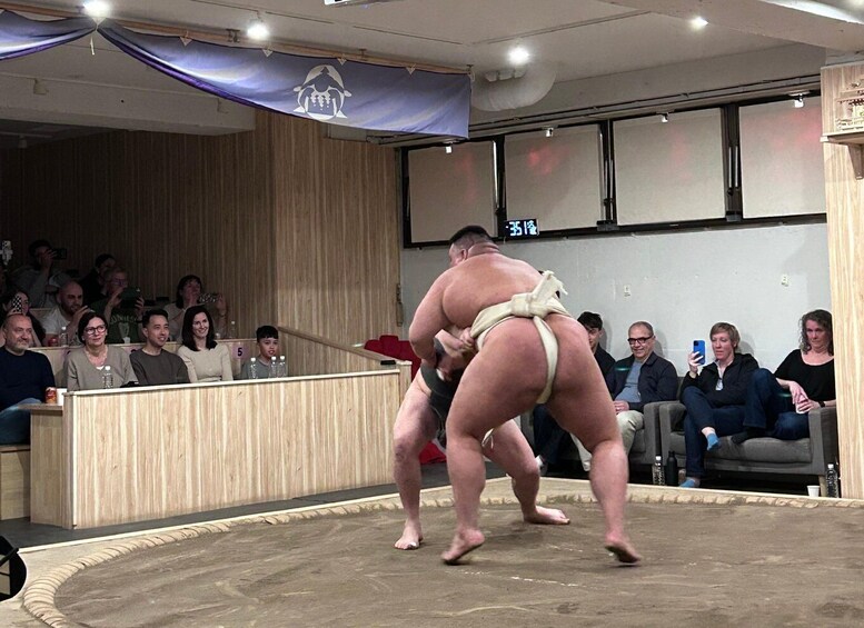 A sumo wrestler in a ring with an audience. 3