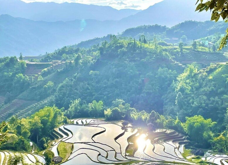 Terraced rice fields, a mountain range, and a small building in the distance. 4