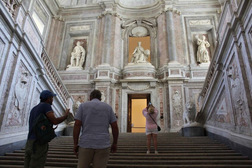 A grand staircase with statues and ornate architecture. 1