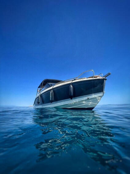 A boat floating on calm water with a clear blue sky in the background. 3