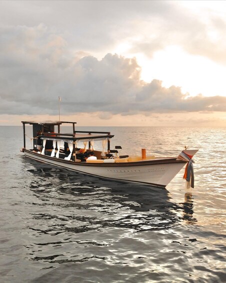 A boat named 'Spalbrity' on calm water with a sunset sky. 1