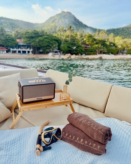A boat deck with a portable radio, sunglasses, and towels. 3