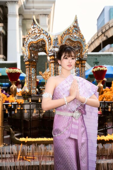 A person in traditional attire standing in front of an ornate temple structure. 3