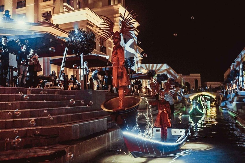 A nighttime scene with a gondola on a canal, a statue with wings, and a building with balconies. 5