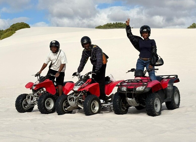 Three people on ATVs in a snowy landscape. 2