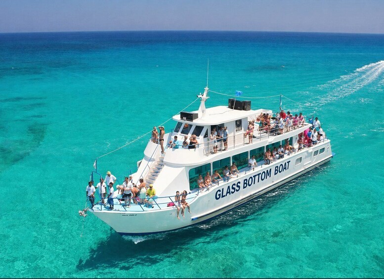 A glass bottom boat named 'GLASS BOTTOM BOAT' with passengers on deck and through the windows. 5