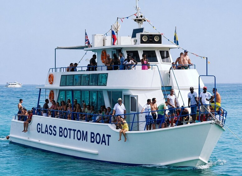 A glass-bottom boat with passengers on deck and in the water. 2