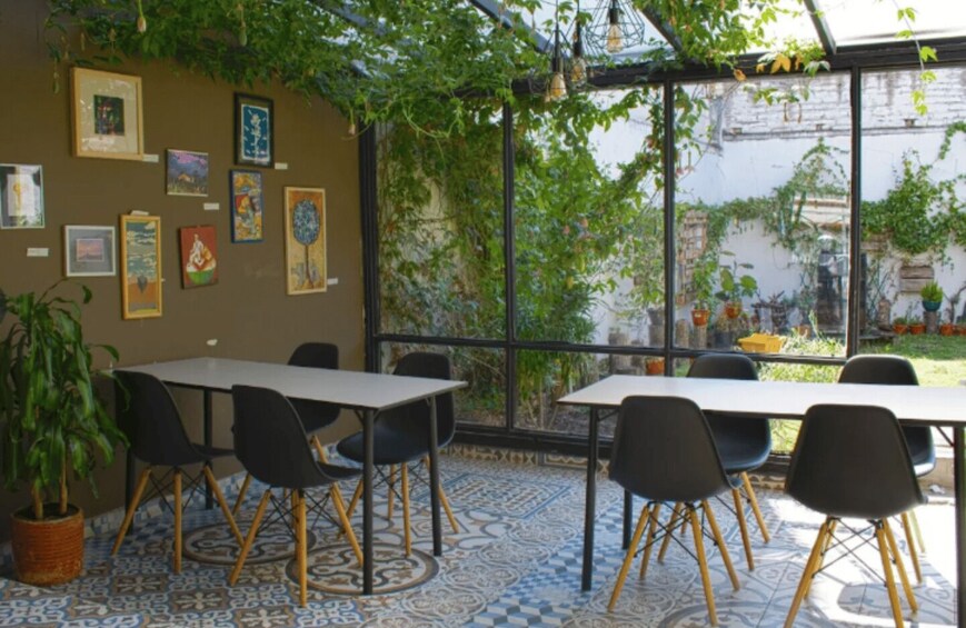 An indoor cafe with tables and chairs, a tiled floor, and a wall decorated with framed artwork. 4