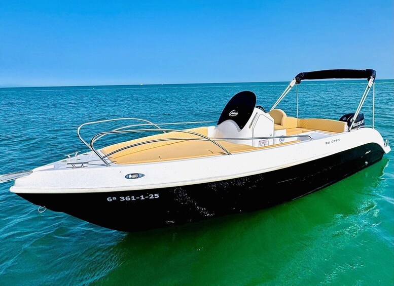 A speedboat with a black hull and a yellow cabin, floating on calm turquoise water. 2