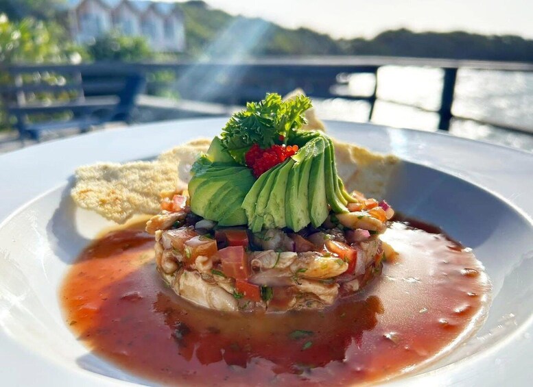 A seafood dish with avocado and a red sauce on a white plate. 3