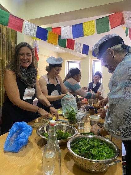 People preparing food at a table with various ingredients and utensils. 2