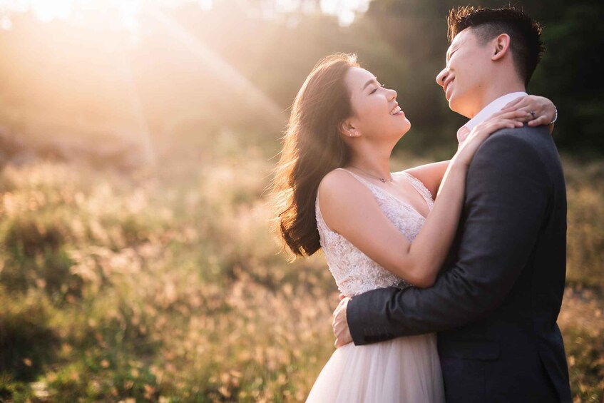 A couple embracing in a field with sunlight. 1
