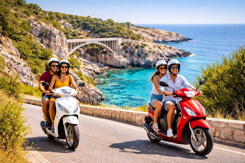 Two people on a white scooter and two on a red scooter on a coastal road with a bridge in the background. 3