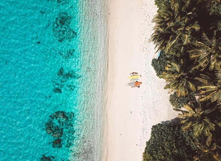 A turquoise beach with white sand and a few people in the distance. 3
