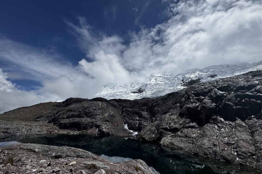 A rocky mountain landscape with a snow-capped peak and a clear sky. 3