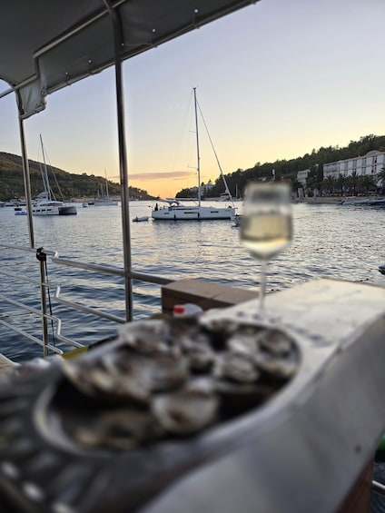 A marina with sailboats, a glass of white wine, and a coastal town in the background. 5