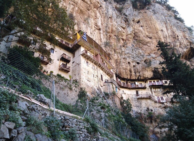 A cliffside building with balconies and a staircase. 2