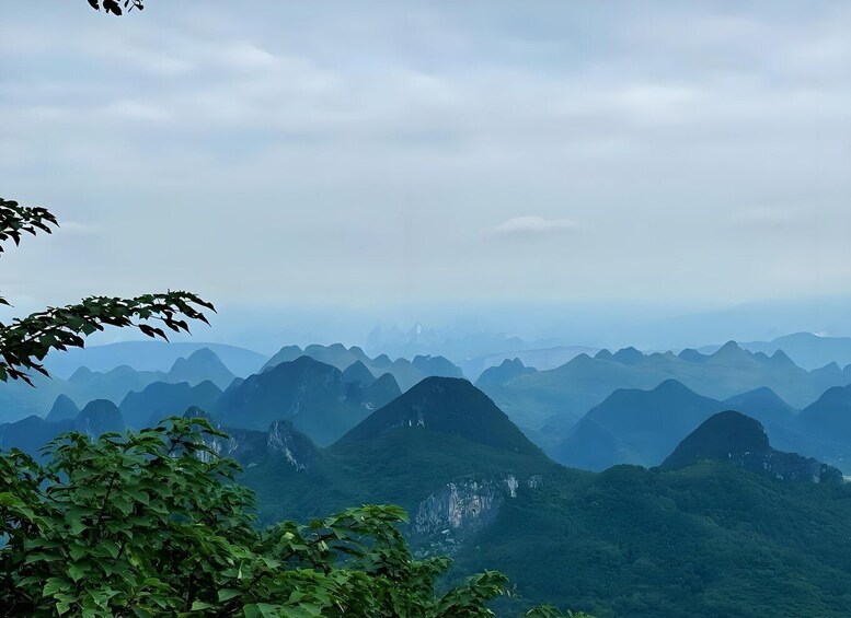 A mountainous landscape with dense green foliage and a cloudy sky. 4
