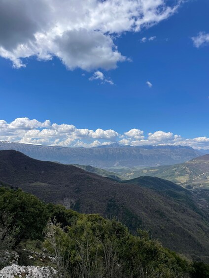 A mountainous landscape with a clear sky and scattered clouds. 2