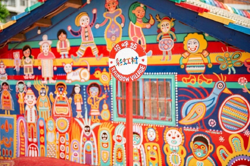 A colorful mural with various figures and a sign that reads 'Rainbow Village.' 5