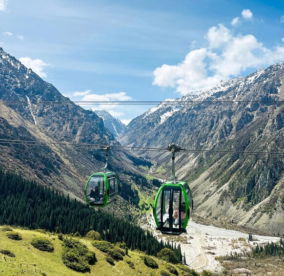A cable car system in a mountainous area with lush greenery and snow-capped peaks. 2