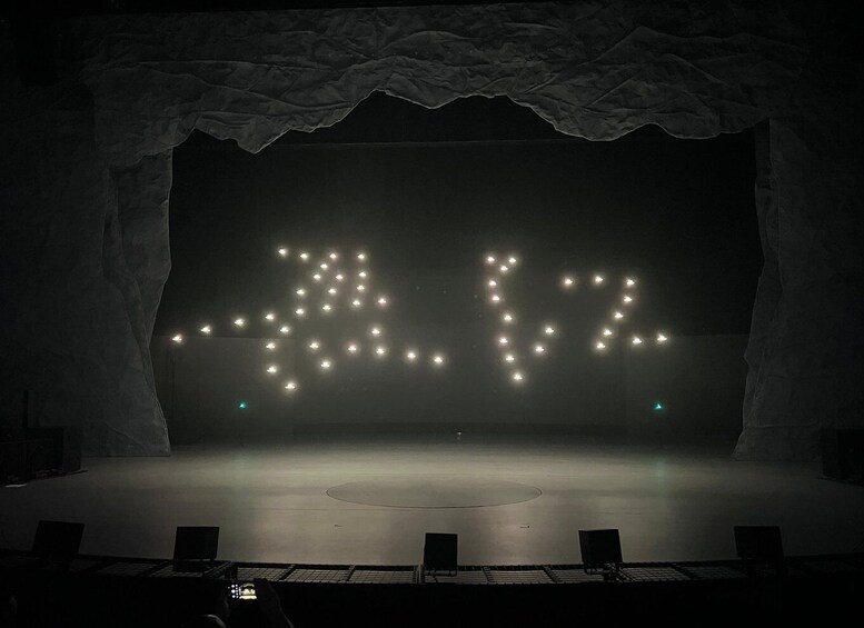 A stage with a backdrop of lights forming the number '42'. 2