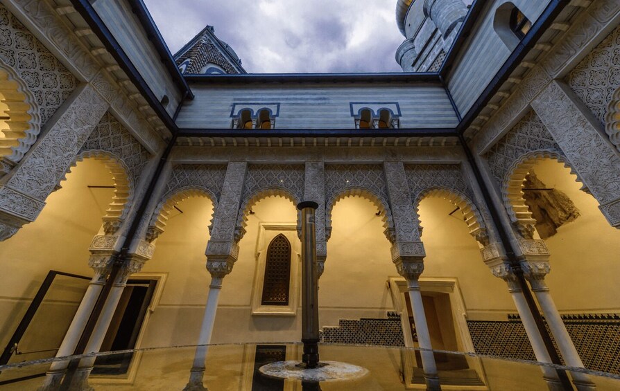 A courtyard with ornate arches and a fountain. 2