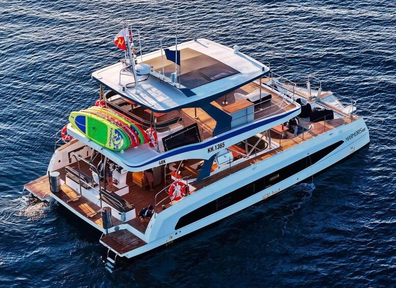 A large, multi-deck yacht with a white hull and blue accents, named 'MARMORIS 88,' sailing on open water. 2