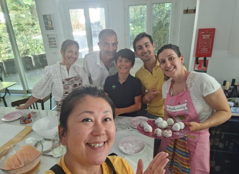 A group of people in a kitchen with food preparation. 1