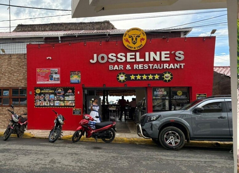 A red building with a sign for Josseline's Bar & Restaurant, a motorcycle parked in front, and a car parked nearby. 3