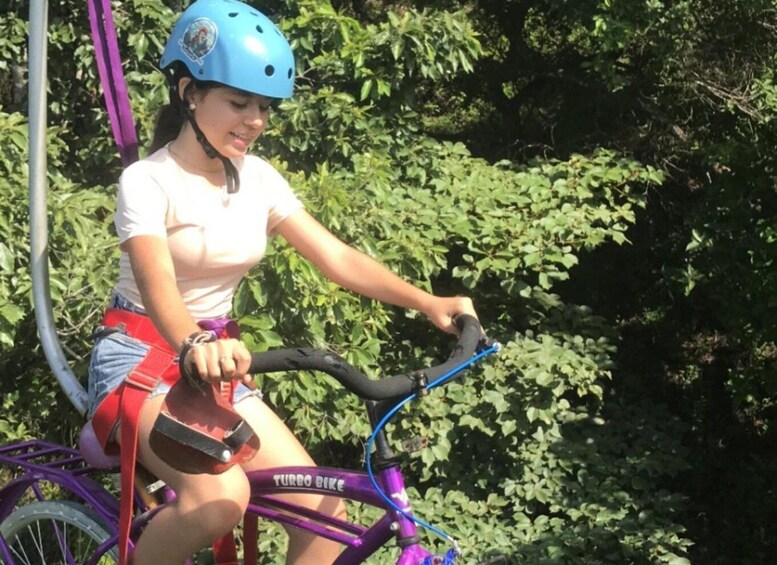 A person riding a purple bicycle with a blue helmet. 4