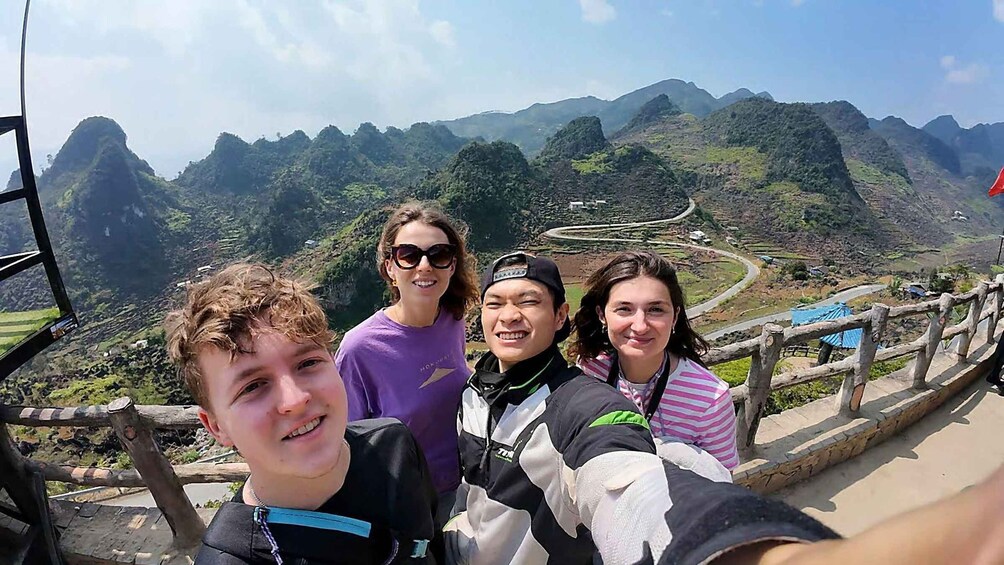 A group of people taking a selfie with a mountainous landscape in the background. 5
