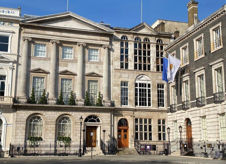 A classical building with columns, arched windows, and a flag. 2