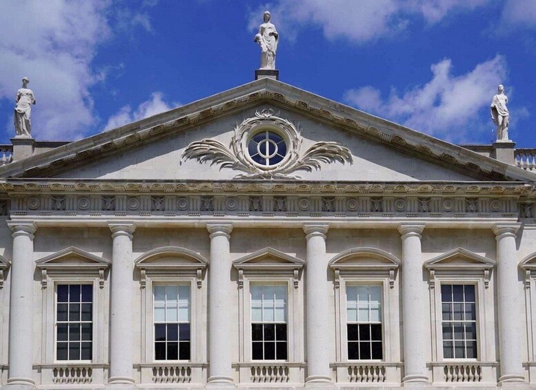 A neoclassical building with a triangular pediment, columns, and statues. 4