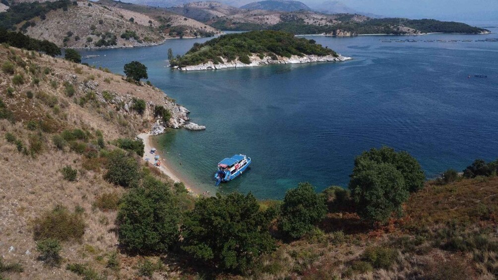 A boat on a calm lake surrounded by hills and sparse vegetation. 4