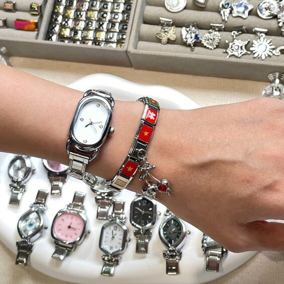A wrist with two watches and a bracelet. 1