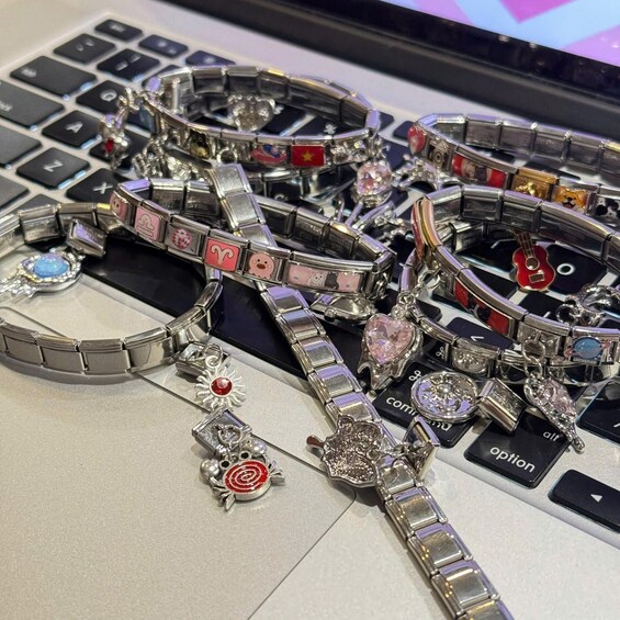 A collection of bracelets with various pendants and charms on a laptop keyboard. 2