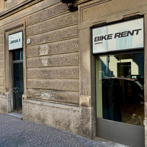A building with a 'BIKE RENT' sign and a 'JOULE' sign on the side. 4