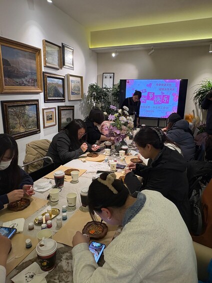 A group of people seated around a table with food and drinks, engaged in a meeting or gathering. 2
