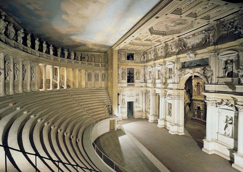 A grand, circular auditorium with classical architecture, including columns and detailed frescoes on the ceiling. 1
