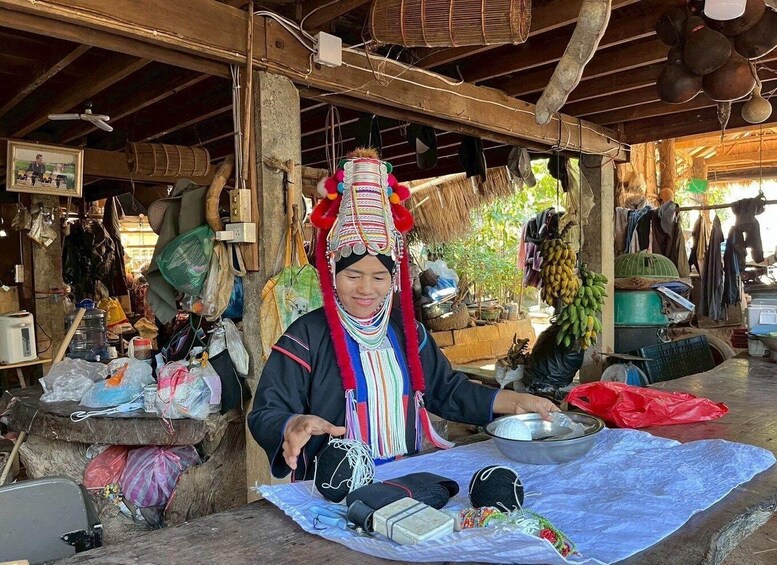 A person at a market stall with various items like a bowl, a metal container, and a blue cloth. 1