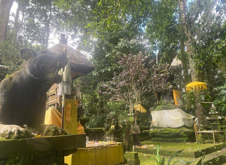 A temple with a large elephant statue, surrounded by lush greenery and traditional architecture. 1