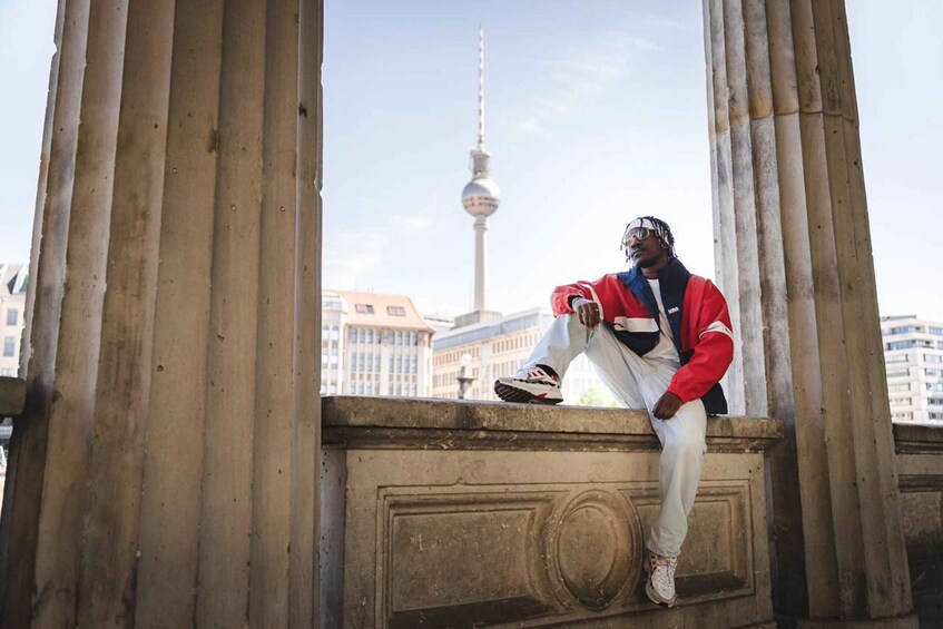 A person sitting on a stone structure with a view of a tower in the background. 2