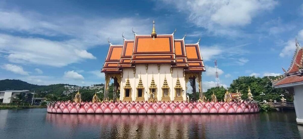 A temple with a golden roof and a lotus base, surrounded by water. 1
