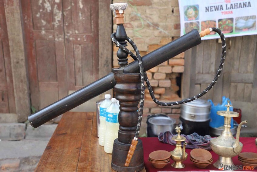 A traditional hookah with a long hose, a wooden base, and a metal bowl. 3