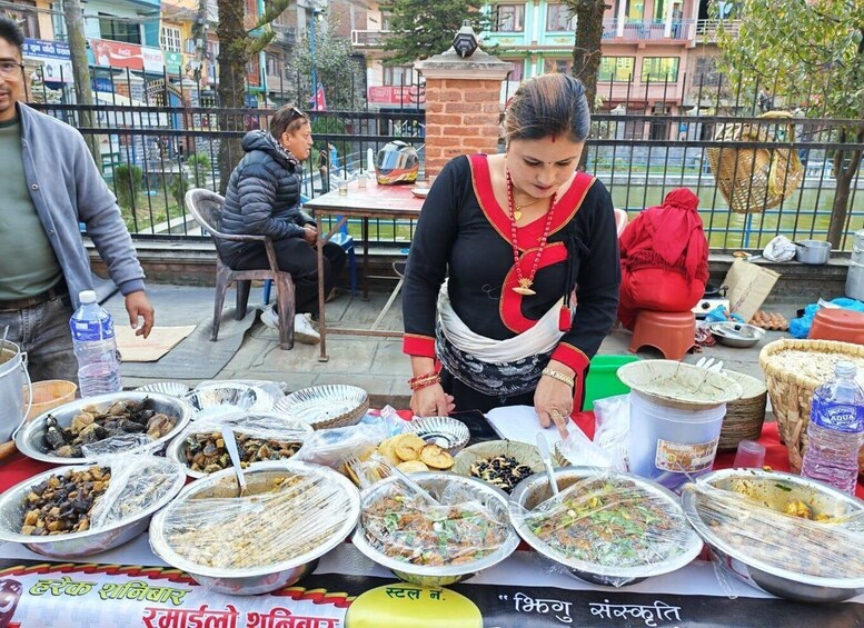 A street food vendor serving various dishes at an outdoor stall. 5