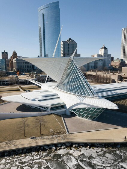 A modern architectural structure with a unique design, surrounded by a cityscape with various buildings. 1