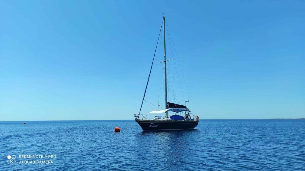 A sailboat named 'Pescador' on calm blue waters. 5