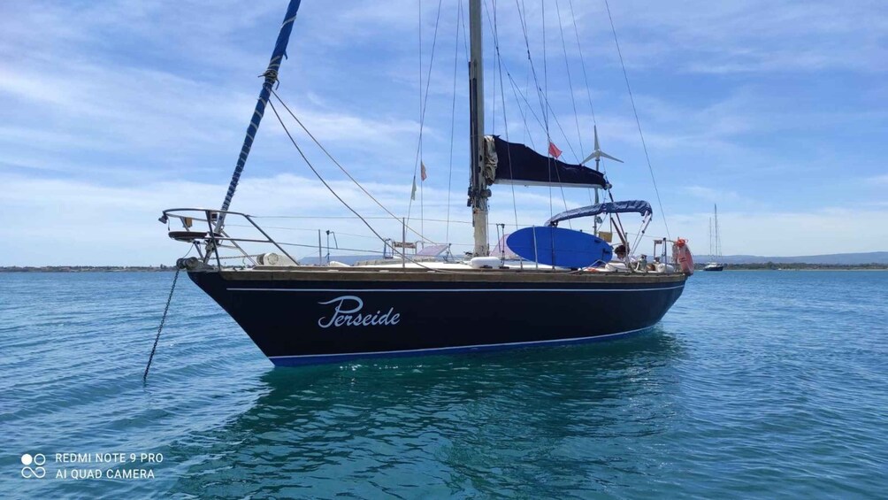 A sailboat named Perseide on calm waters with a clear sky. 1